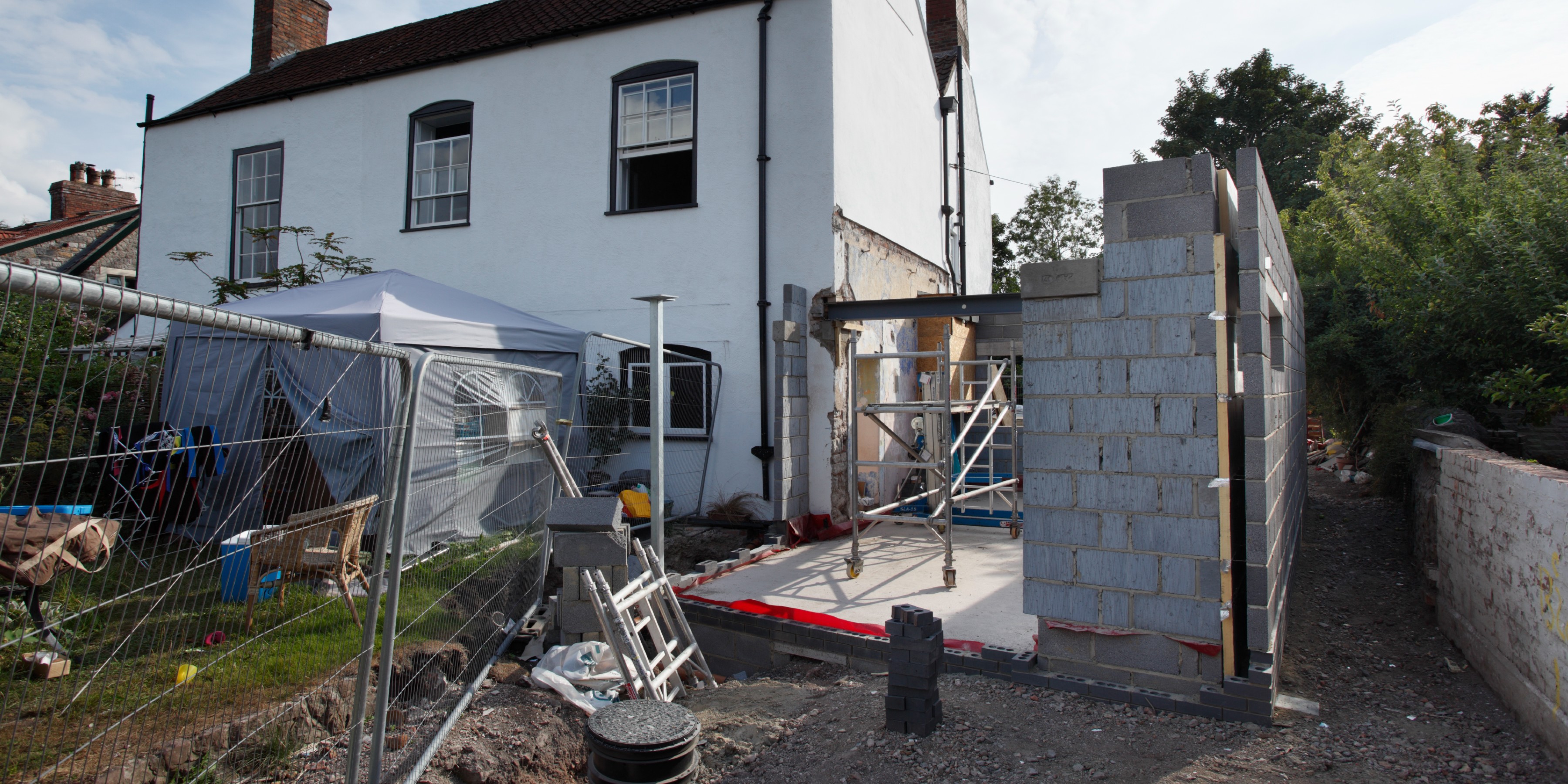 Process of building an extension to a older white rendered house