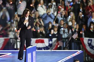 A photo of Kamala Harris sporting pointy black pumps with a bubble bath pink manicure.