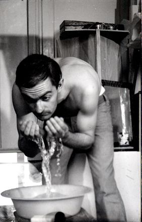 Topless man washing his face