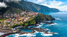 The coastline in Seixal, Madeira, with colorful houses overlooking the blue Atlantic Ocean