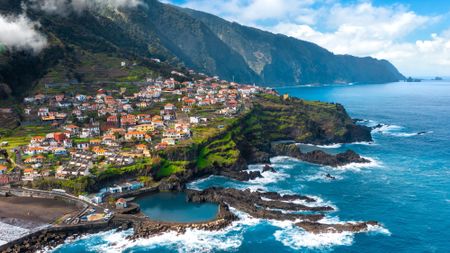 The coastline in Seixal, Madeira, with colorful houses overlooking the blue Atlantic Ocean