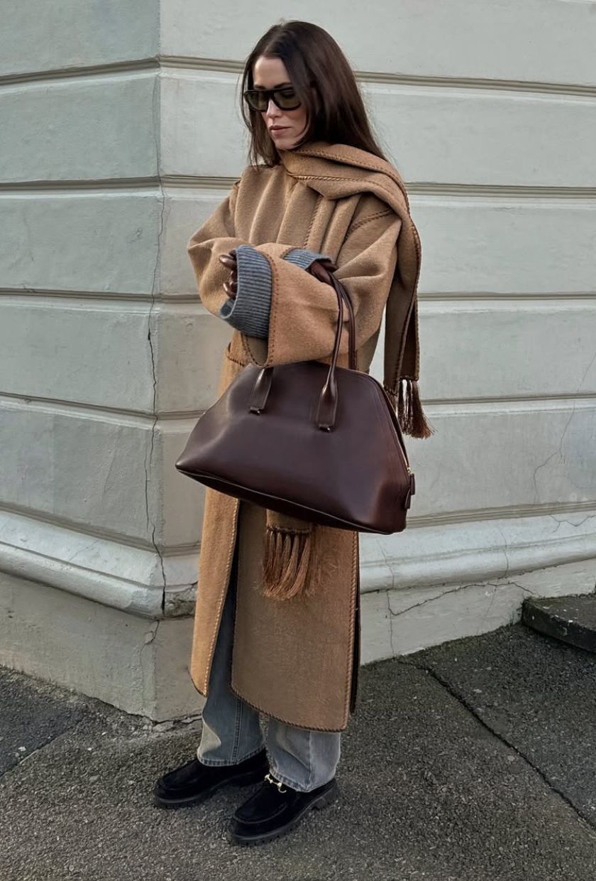 @annabelrosendahl wears a camel scarf coat, grey jeans. black suede loafers and burgundy tote