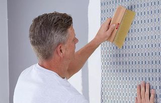 Man using wallpaper hanging brush