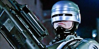 Robocop holding a gun on the mean streets of Detroit