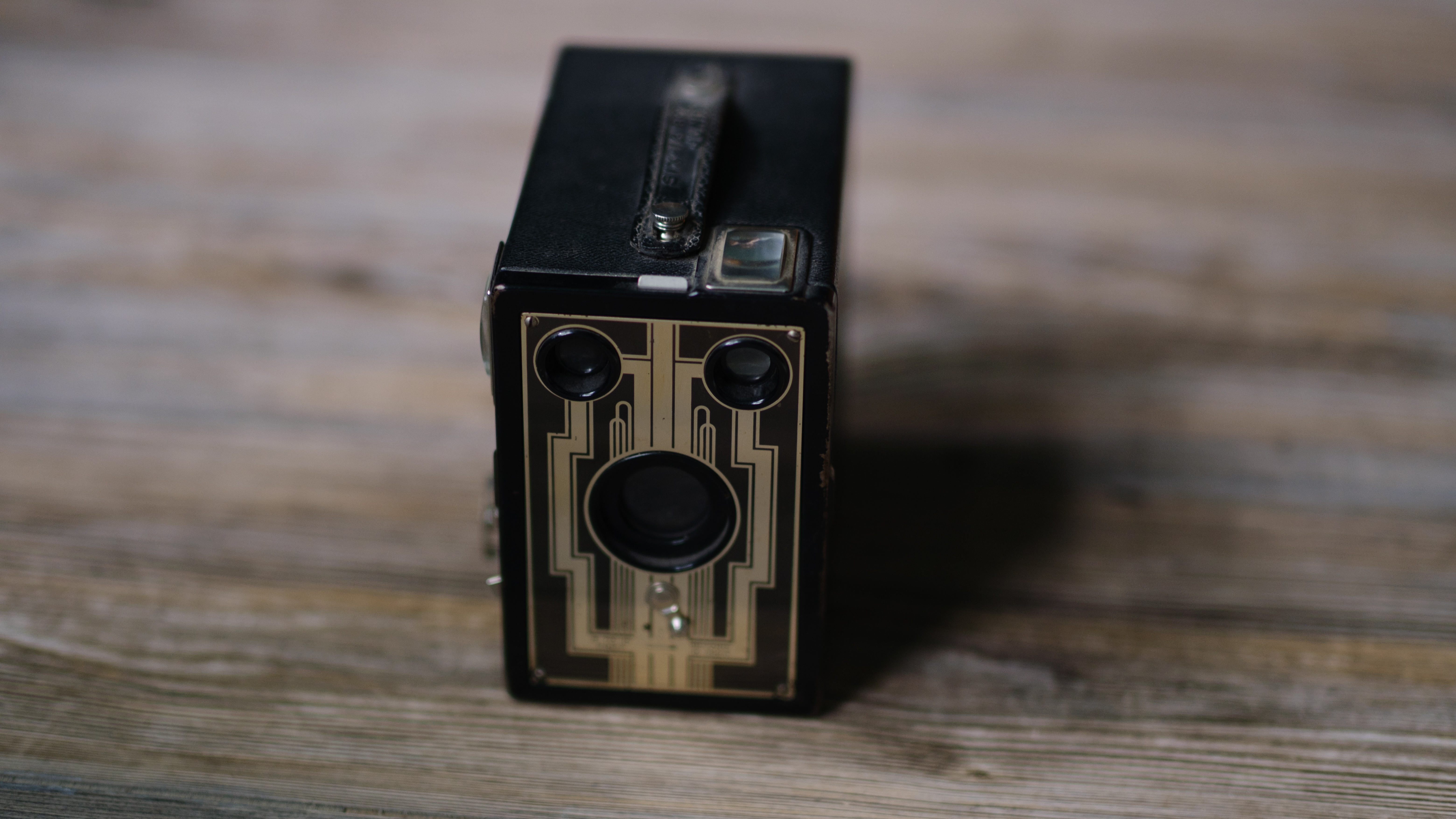 A photo of a vintage box camera taken under different lighting conditions