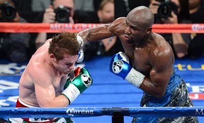 Floyd Mayweather Jr. hits Canelo Alvarez in the fifth round of their WBC/WBA 154-pound title fight at the MGM Grand Garden Arena on September 14, 2013 in Las Vegas, Nevada. Mayweather won by 