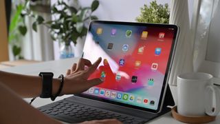 Femme utilisant l'Apple iPad pro 2018 sur une table de bureau à domicile.