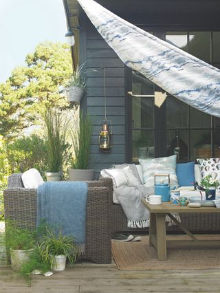 deck with grey panelling and sofa with blue and white cushions