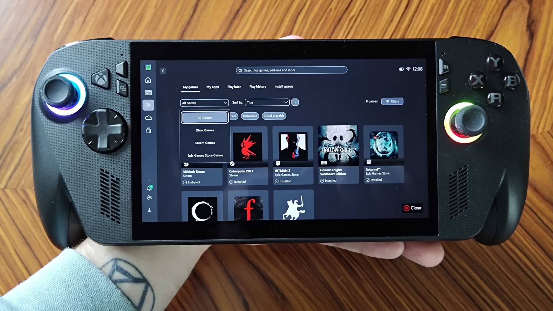 Hand holding ROG Xbox Ally X with Xbox app on screen.