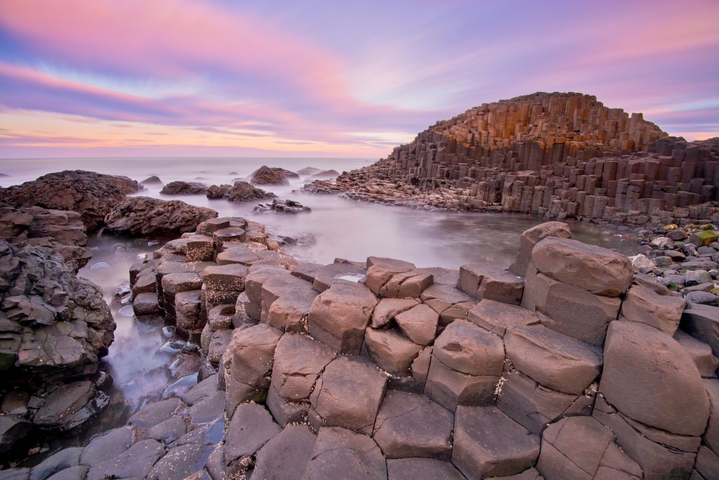 Ireland. County Antrim. Giants Causeway. Dramatic colourful cloud pattern over the rocks at sunrise.