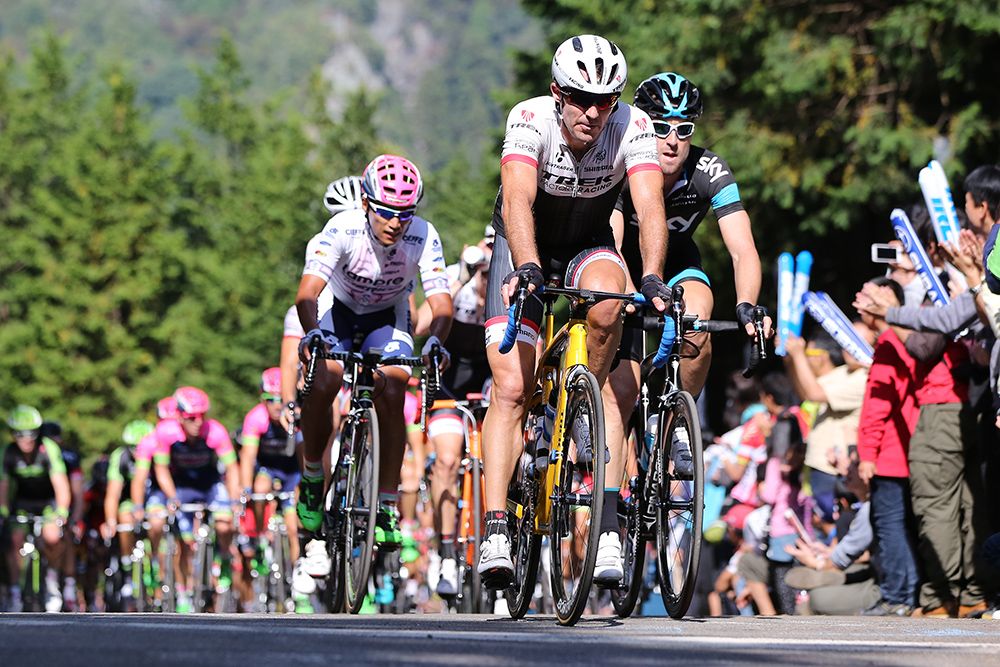 The bunch comes up the climb