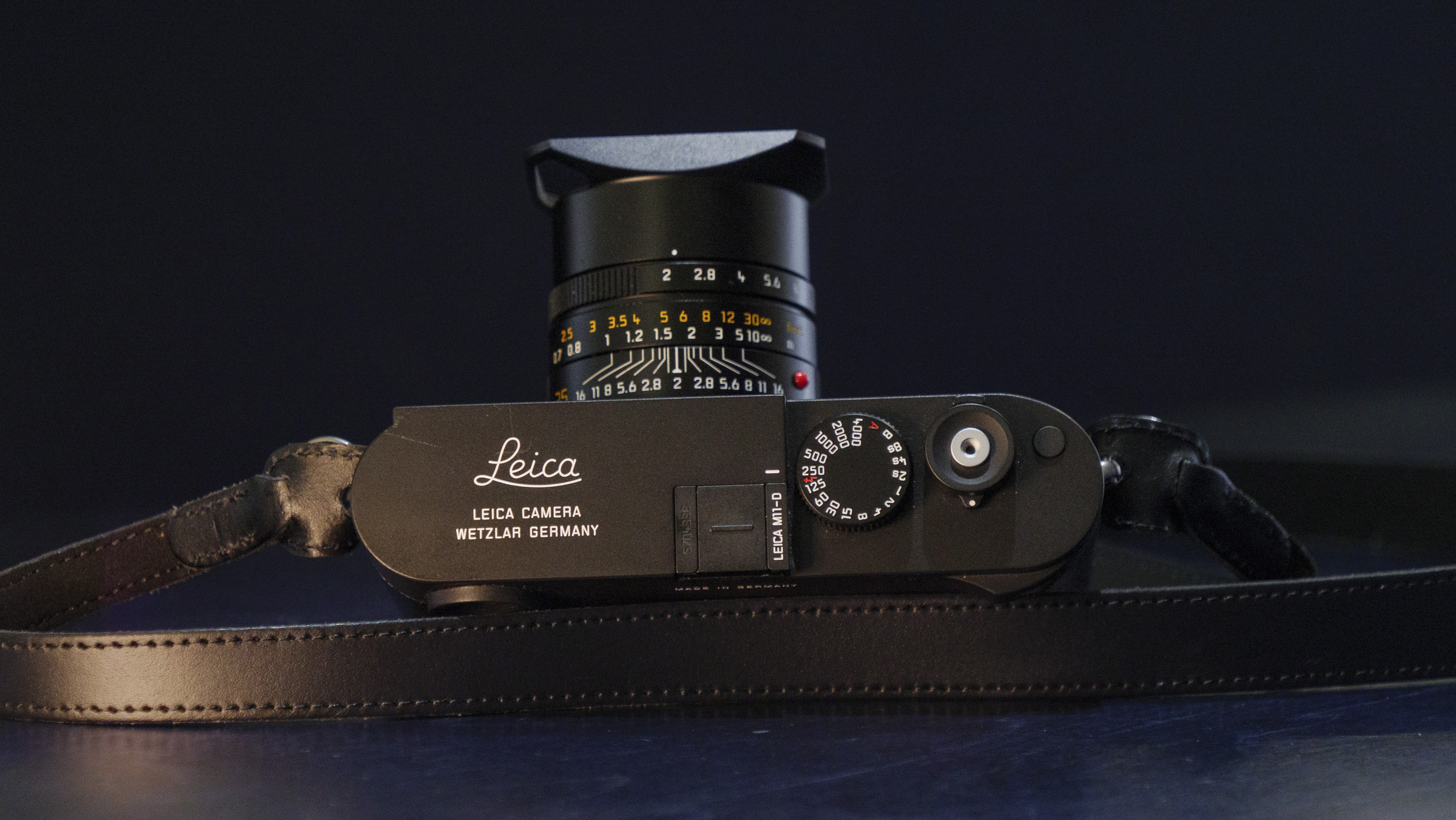 Leica M11-D camera on a dark blue table, low key lighting