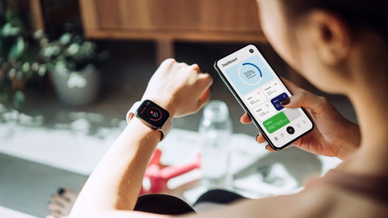 woman looking at one of the best workout apps with fitness tracker