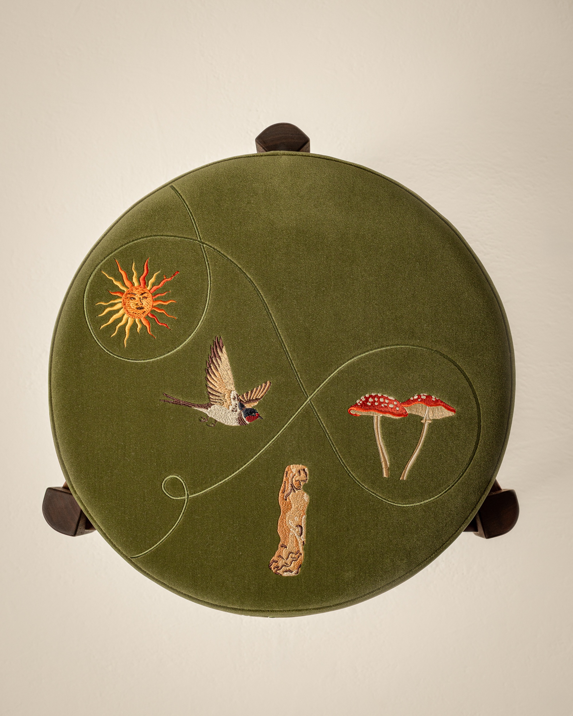 embroidered motifs on a velvet footstool