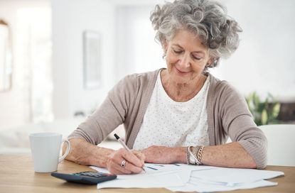 Pensioner calculating her expenses for the month.