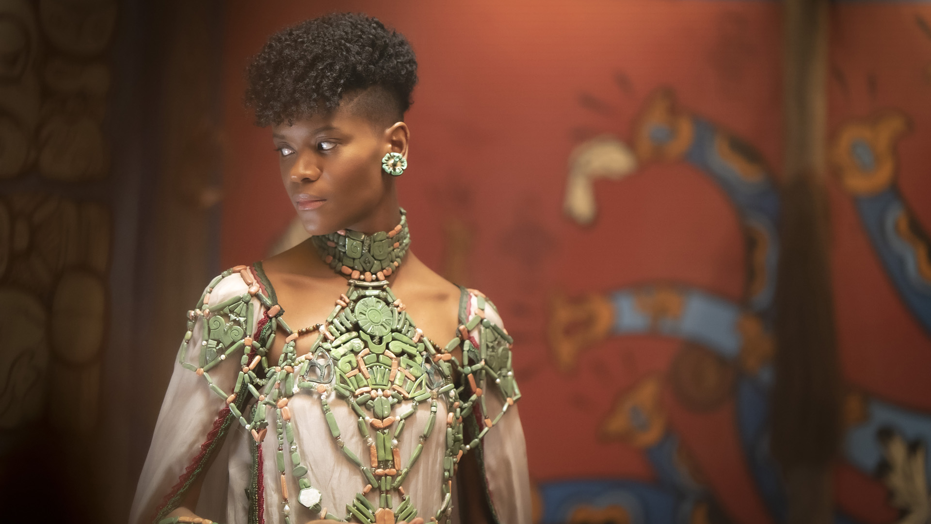 Shuri looks to her right as she wears a Talokanil dress in Black Panther 2