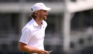Tommy Fleetwood walking off the green whilst smiling