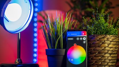 The best smart bulbs: Image depicts lamp with coloured bulb controlled by app on phone