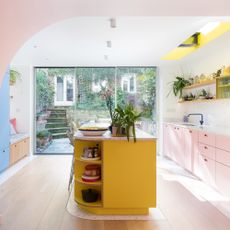 kitchen with pink and blue cabinets yellow island