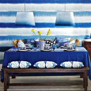 dining are with tie dyed printed shades on wall and cushion