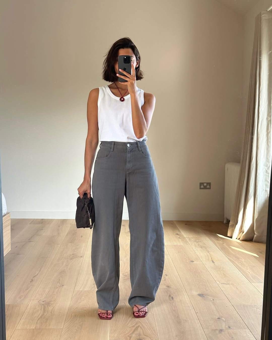 Marianne in grey barrel jeans and red strappy sandals