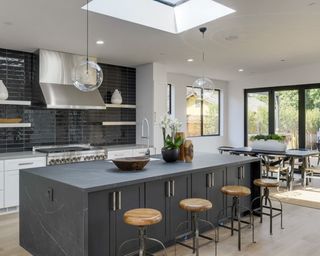 A modern kitchen with a dark waterfall countertop