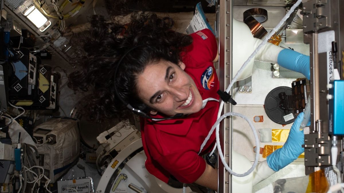 jasmin moghbeli smiling beside a science cabinet