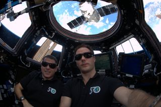 Thomas Pesquet takes a selfie with Shane Kimbrough in the Cupola at the International Space Station. The SpaceX Dragon cargo ship can be seen through the window.