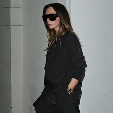 Victoria wears a black blazer and large black sunglasses.