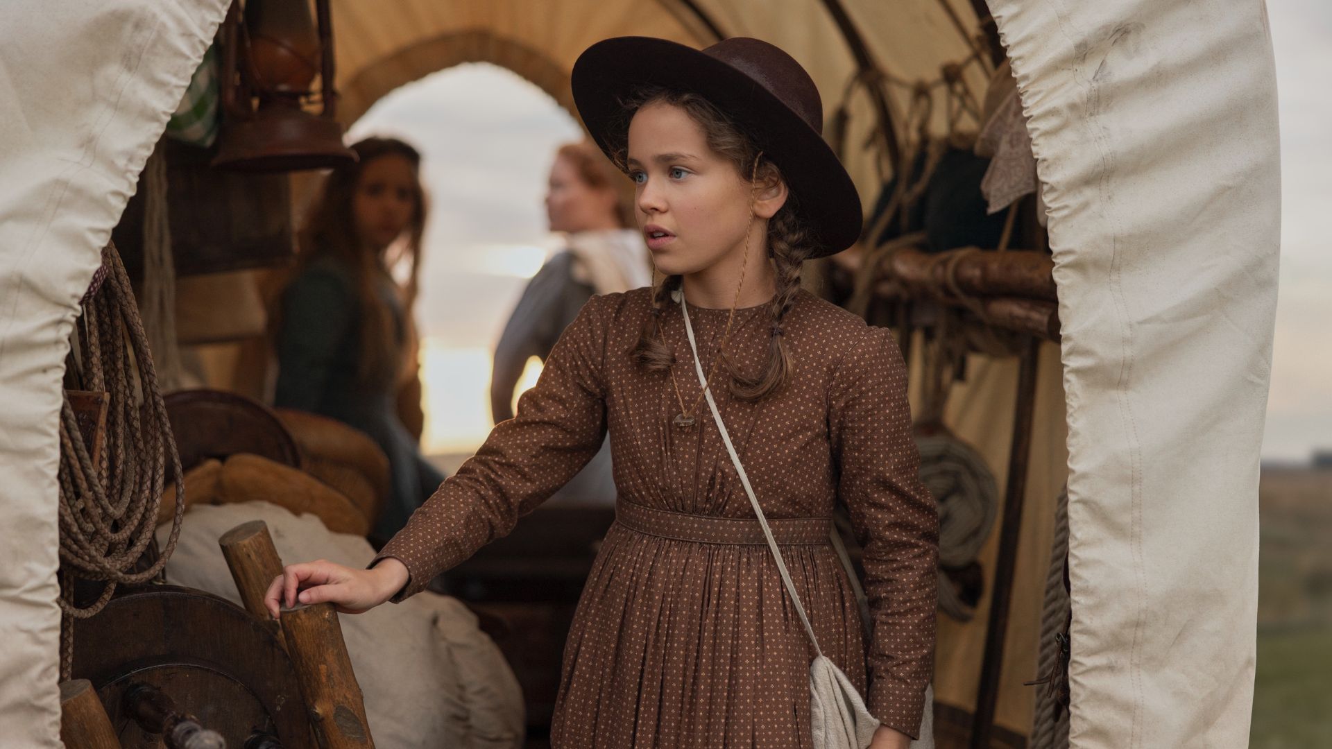 Laura stands in the back of a wagon