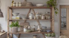 A rustic kitchen shelf with glass bottles of spices and cooking ingredients