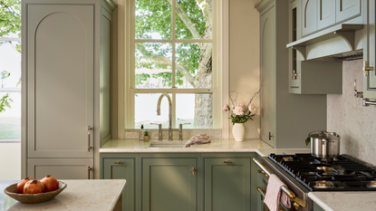 modern shaker kitchen with light sage cabinets and a range oven