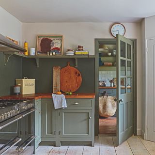 Shaker style kitchen with olive green painted floor cabinets and open shelf