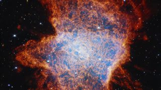 A glowing nebula of blue and red and white lights gleams in the darkness of outer space