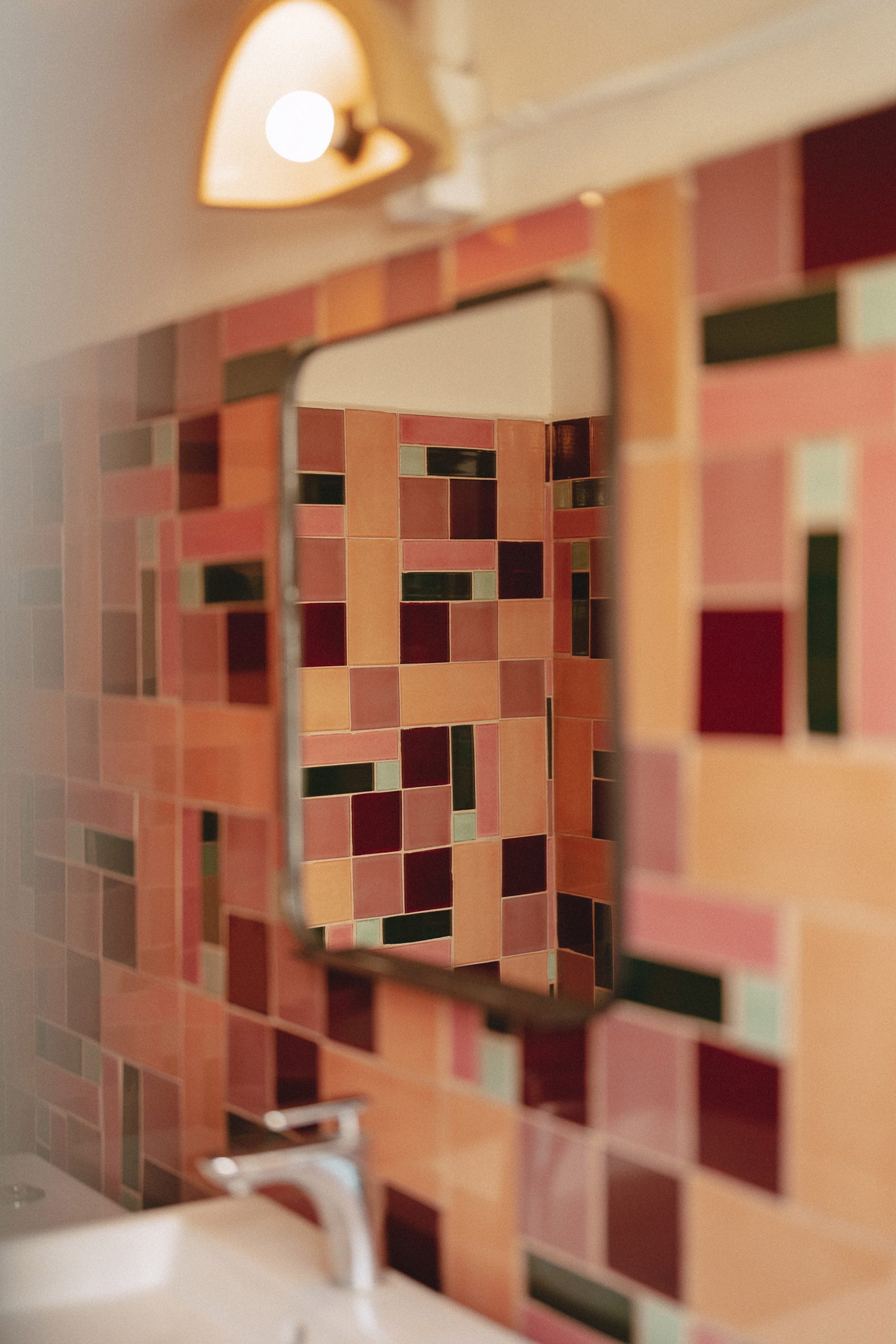 A vibrantly decorated hotel featuring a pastel palette of pinks, greens, and browns, tiled surfaces, and a vaguely Art Deco, contemporary feel.