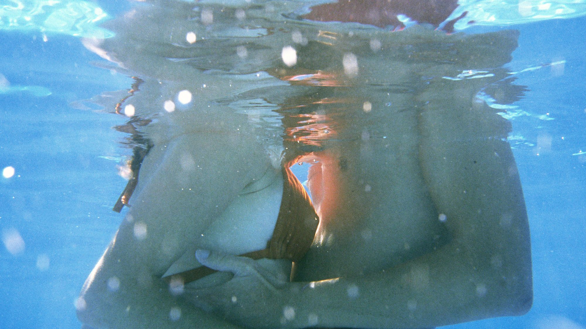 Couple embracing, mid-section, underwater view - stock photo