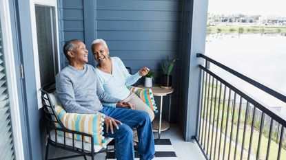 Senior couple sitting on the porch of their Florida retirement home