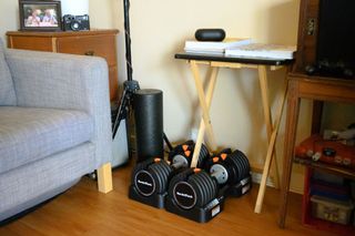 NordicTrack Select-a-Weight Adjustable Dumbbells stored under a collapsible desk