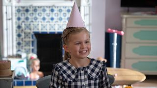 Pheobe wearing a party hat and smiling.