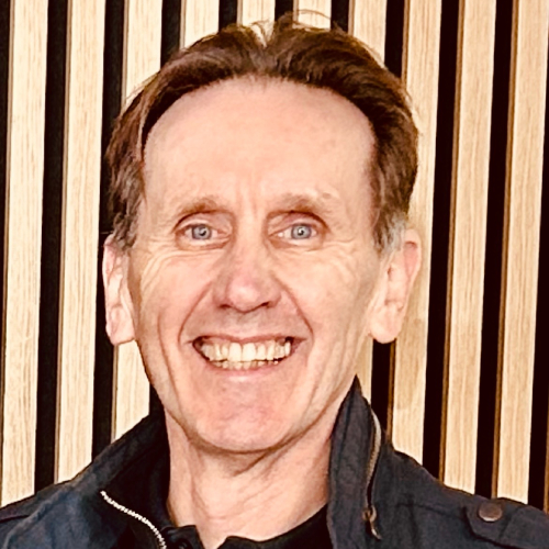 male with short brown hair stood in front of timber panels