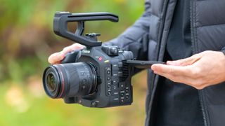 Person holding a Canon EOS C80 cinema camera outside