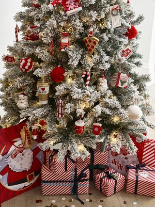 Christmas tree with red and white decorations, matching presents underneath