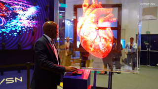 A digital image of the heart appears in front of a man at a podium thanks to HYPERVSN technology.
