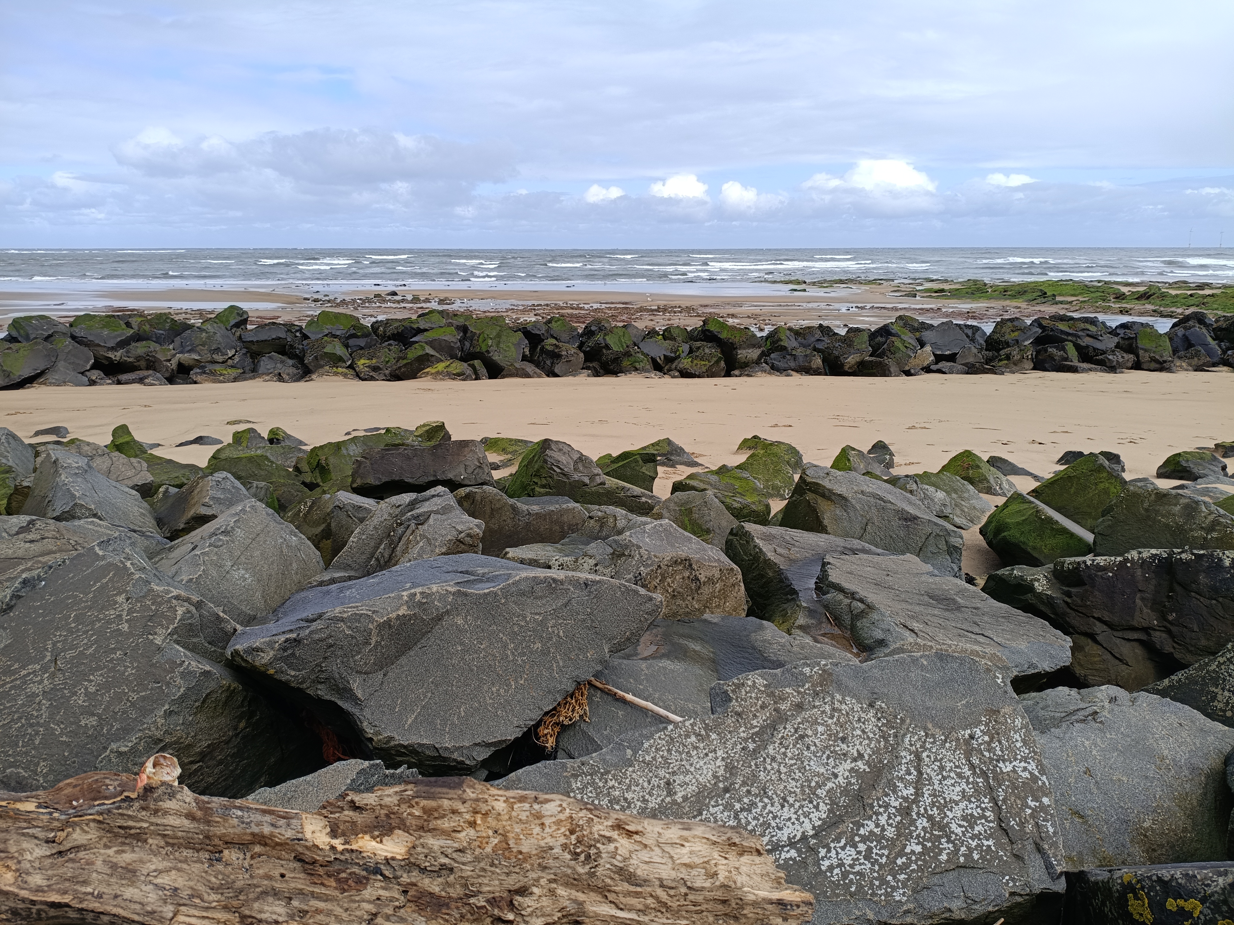 Rocky beach at low tide under a cloudy sky