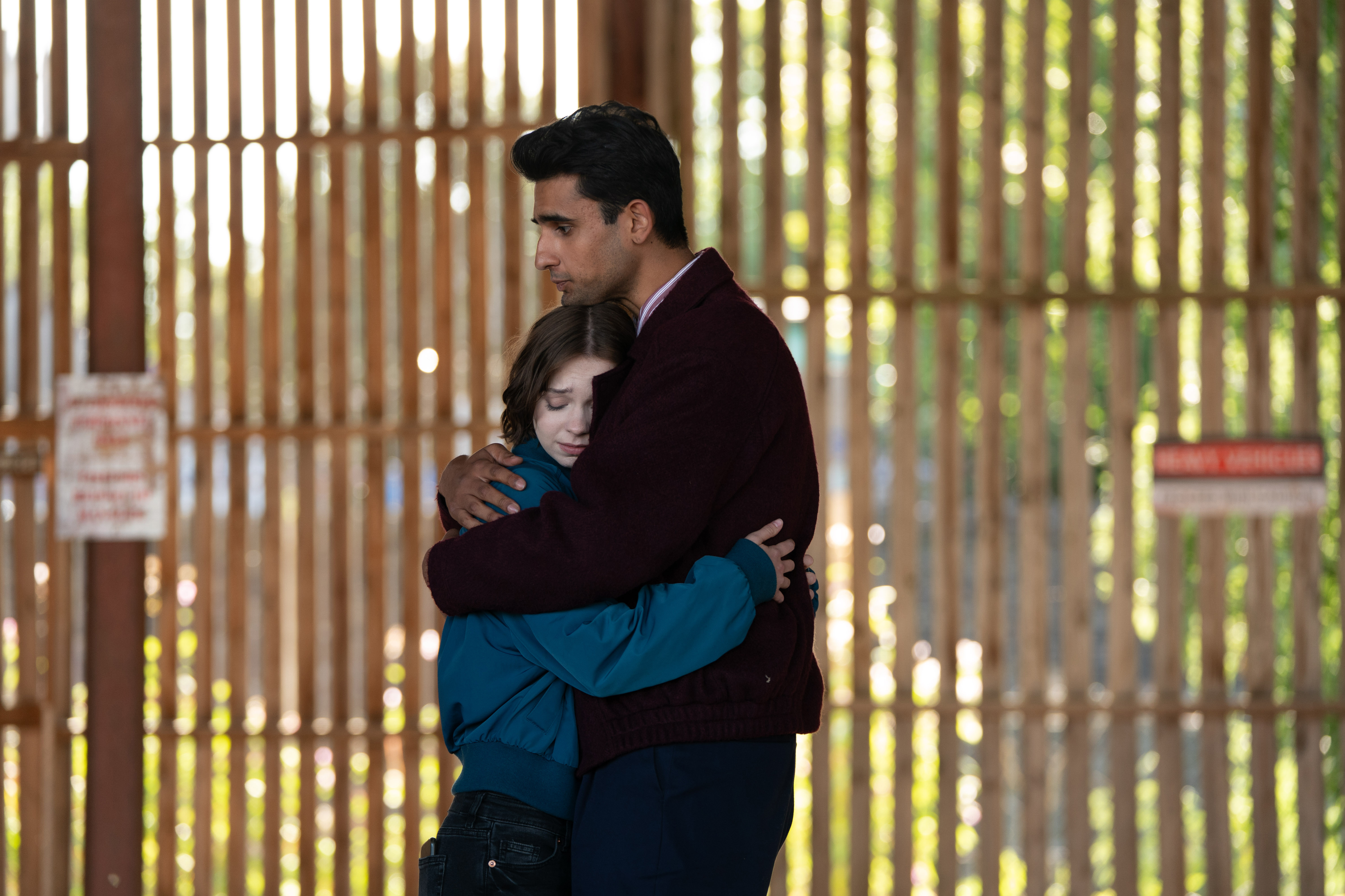 Emma Myers as Pip Fitz-Amobi hugging Zain Iqbal as Ravi Singh on a dimly lit street in A Good Girl's Guide to Murder: Season 2