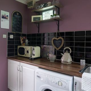 purple wall kitchen with worktop and white drawers