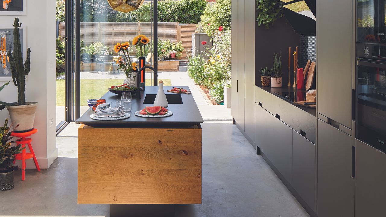 Black kitchen with wooden island and dark worktops