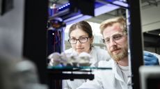 Two engineers using a 3D printer