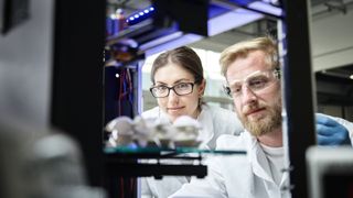 Two engineers using a 3D printer