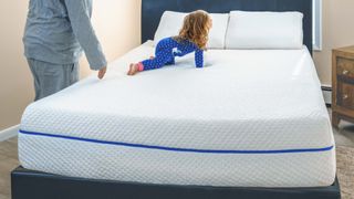 Best mattress for side sleepers: image shows a child in blue pyjamas climbing on SleepOvation mattress